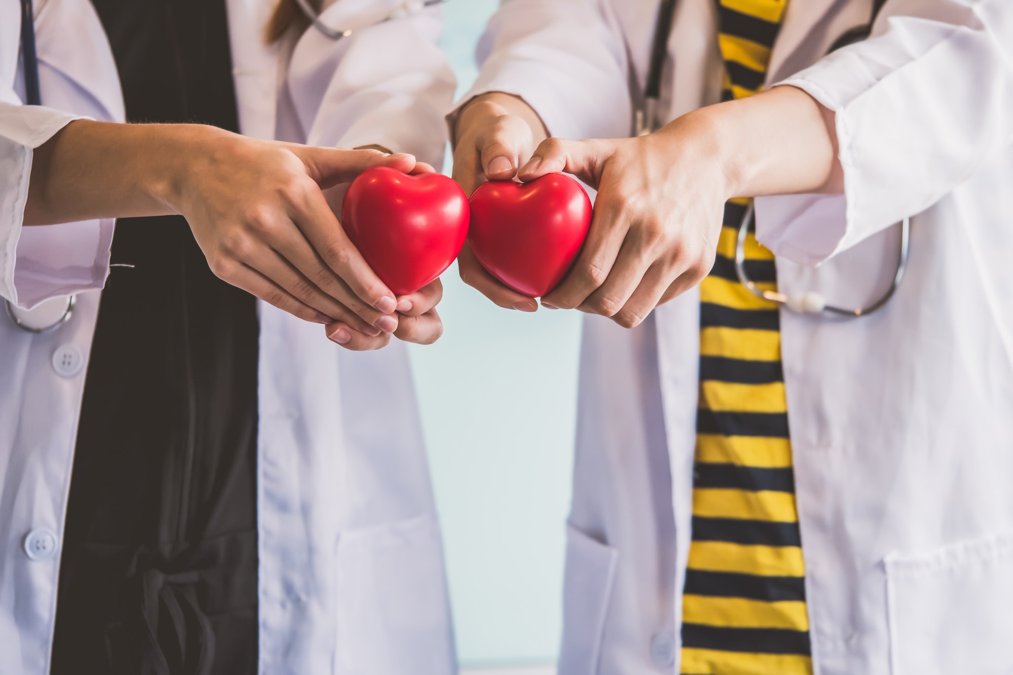 Two doctors holding red heart, health care concept.