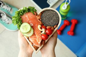 Female hands hold healthy food in heart, top view