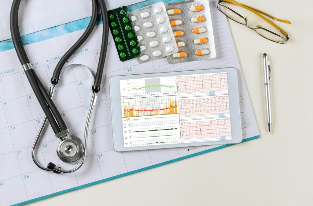 Medical examination with cardiologist reading electrocardiogram of ECG analyzing symptoms to make a